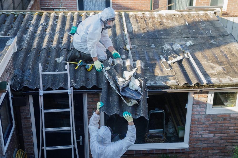 Technician safely removing asbestos sheeting
